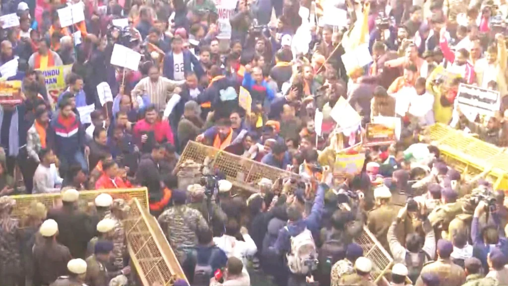 Protesters attempt to enter the Bangladesh High Commission by breaking barricades in New Delhi